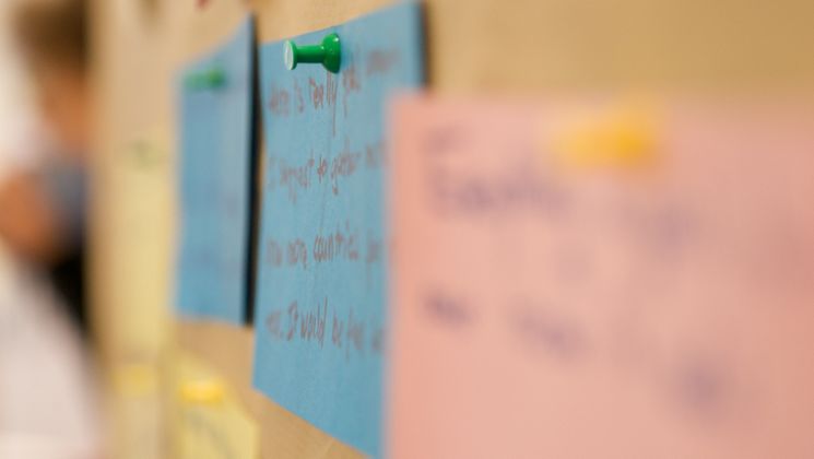 Notizen zu einer Jugendbegegnung werden auf eine Pinnwand geheftet