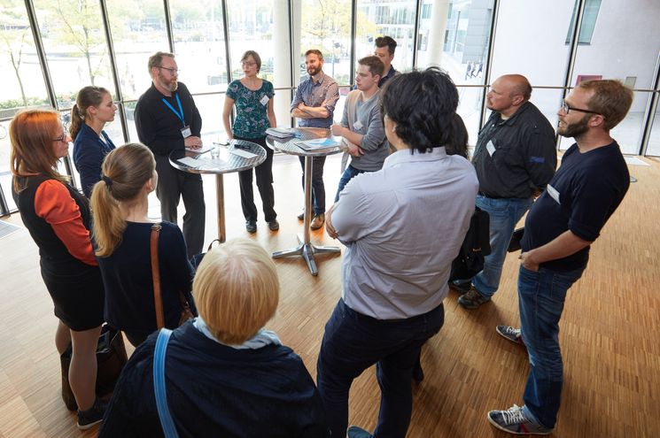 Menschen stehen im Kreis und diskutieren