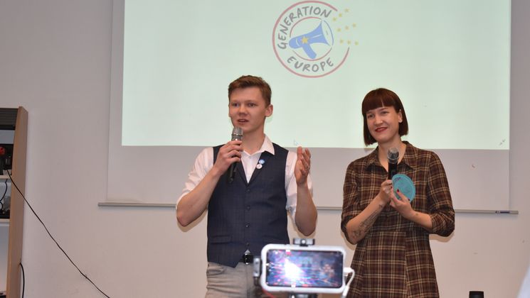 Zwei junge Menschen vor dem Logo von Generation Europe / Foto: Internationales Bildungs- und Begegnungswerk e.V.