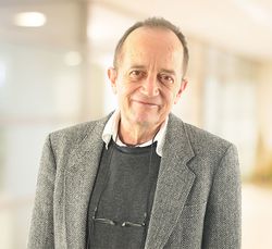 Dr. Thomas Grobe in grauem Sakko vor unscharfem Hintergrund.