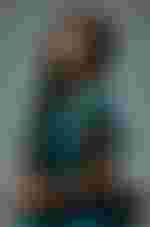 Eine Frau in einem blauen Kleid, die auf einem Stuhl sitzt