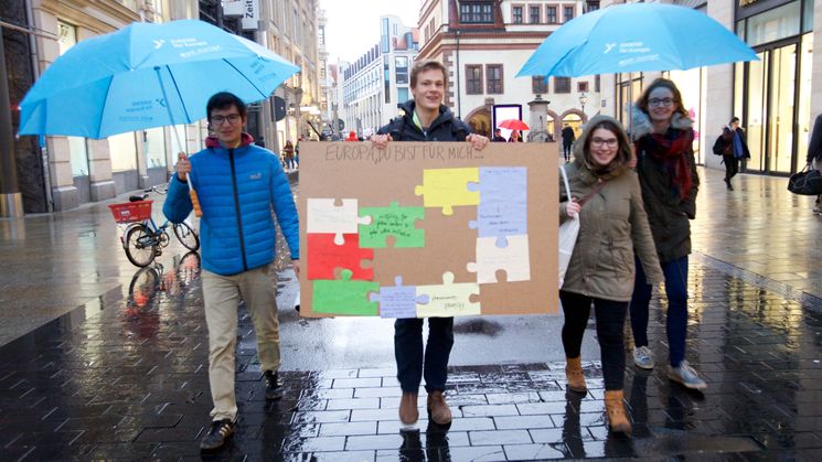 Vier Jugendliche mit einem Pappschild, auf dem steht: Europa bedeutet für mich..."