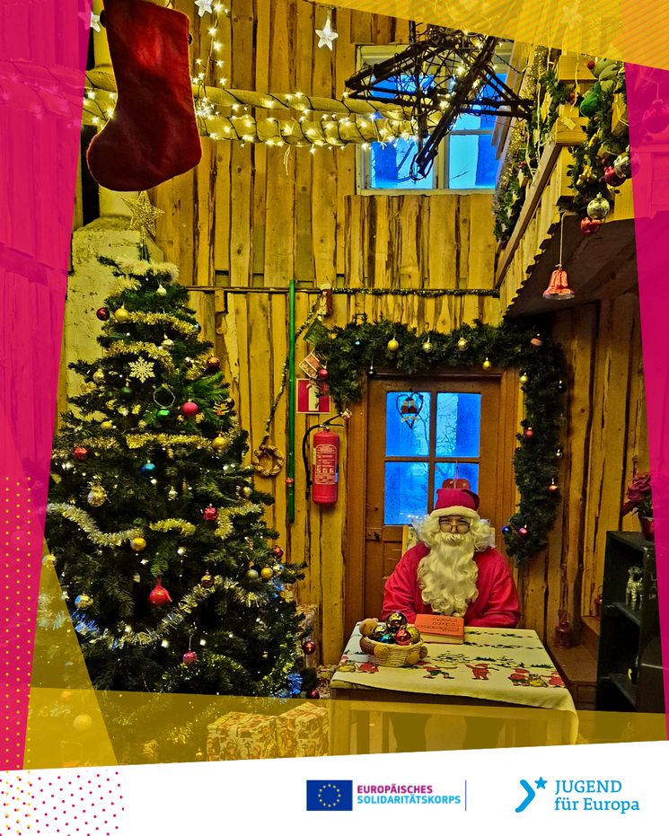 Santa Claus sitzt in einem festlich geschmückten Haus neben einem Weihnachtsbaum und Geschenken